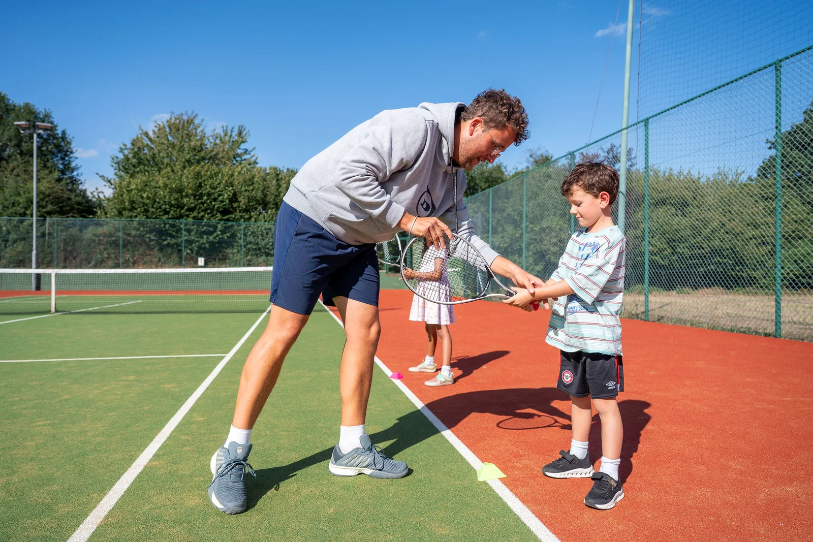 Young players running and rallying with a Tennis by Sam coach