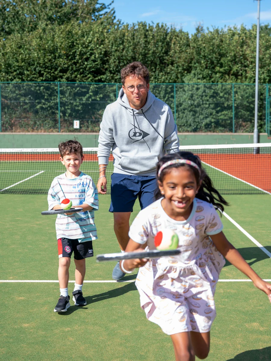 Children playing a tennis game with a Tennis by Sam coach